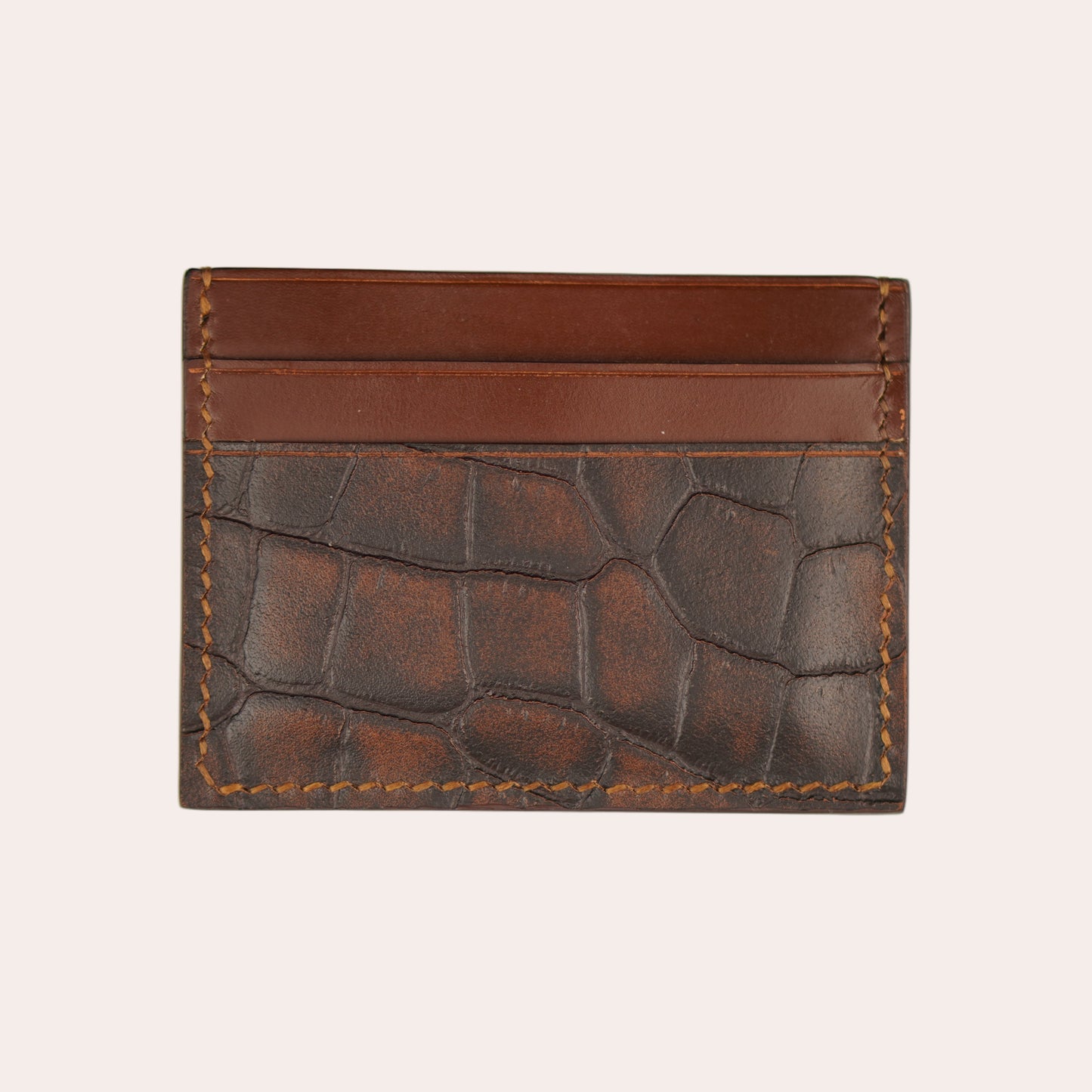 Brown leather wallet with embossed pattern on a white background