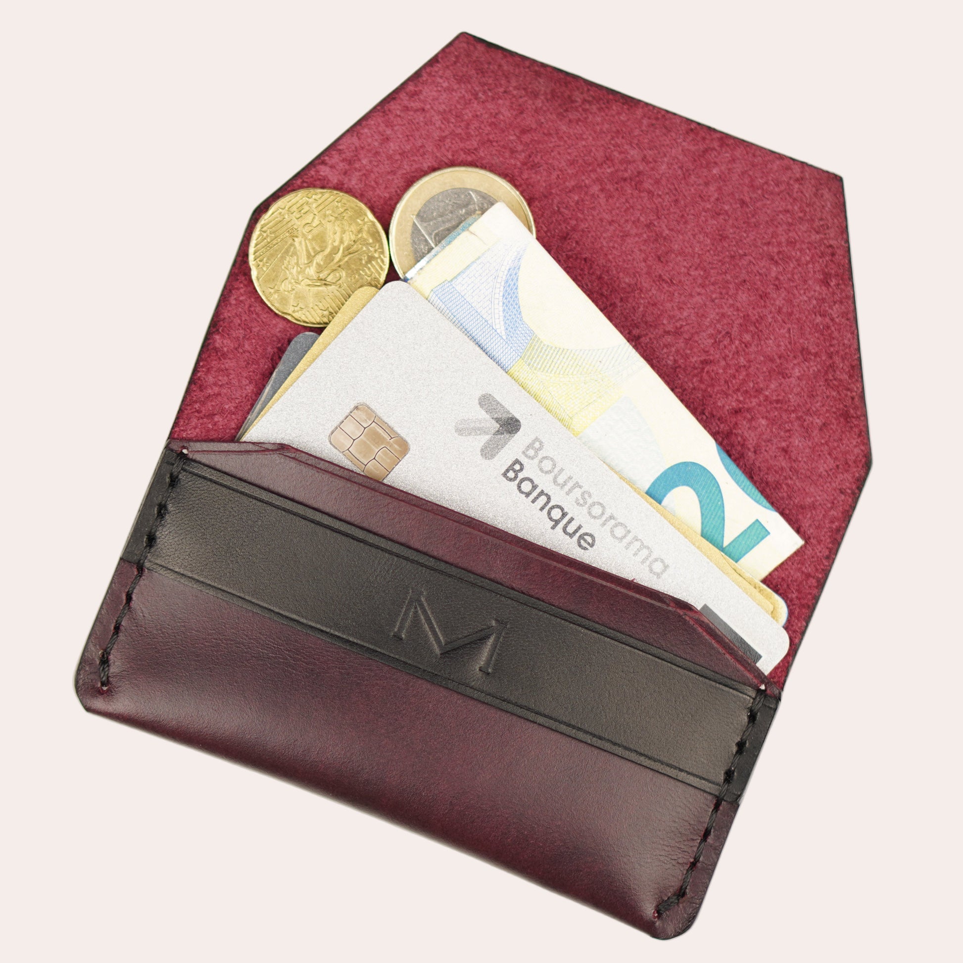 Brown leather wallet with coins and cards on a white background