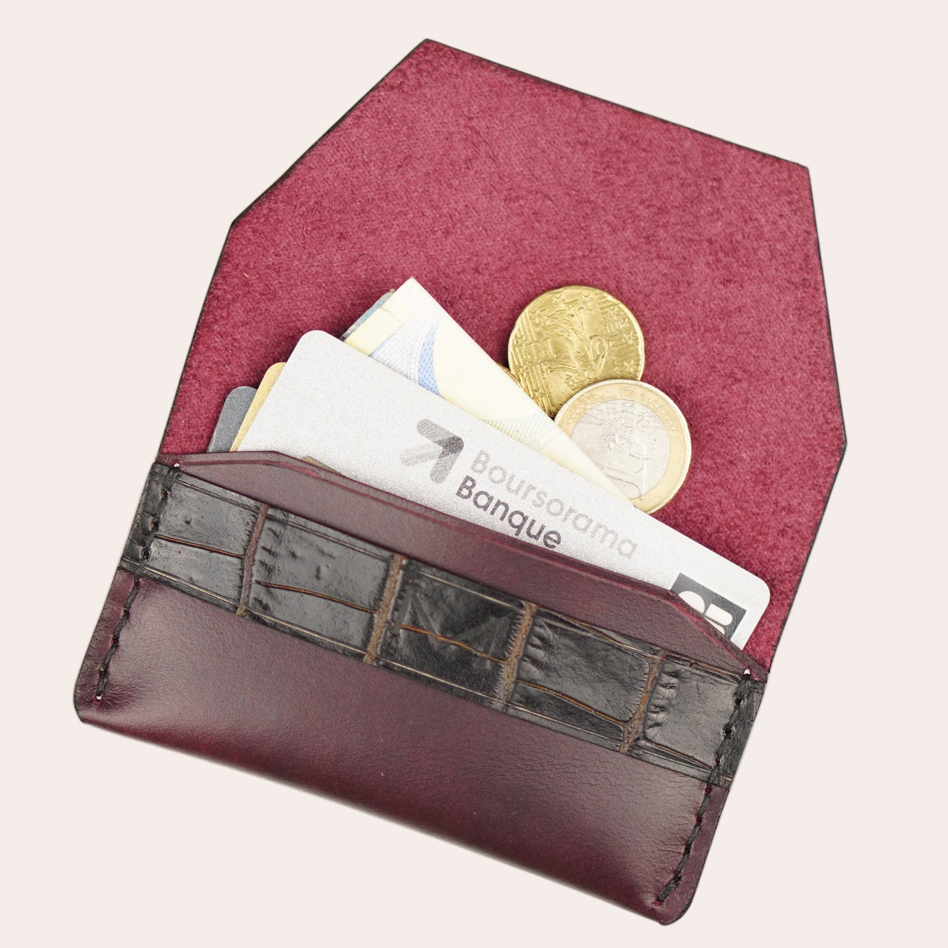 Red wallet with coins and banknotes on a white background