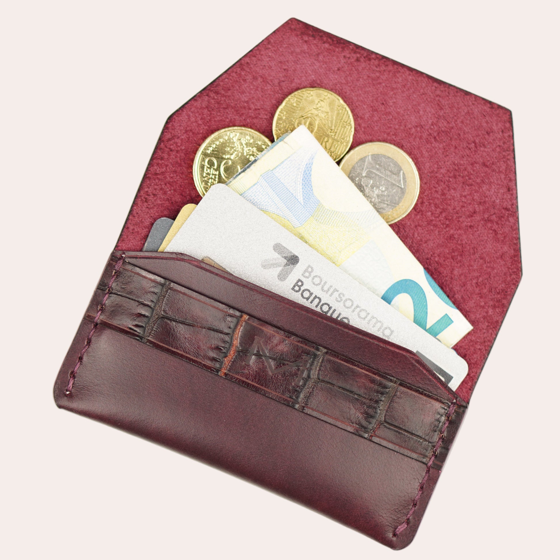 Red coin purse with coins and cards on a white background