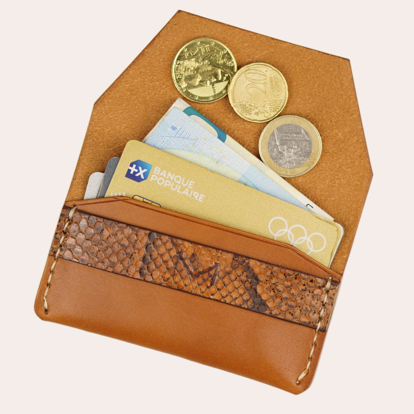 Brown leather wallet with coins and cards on a white background