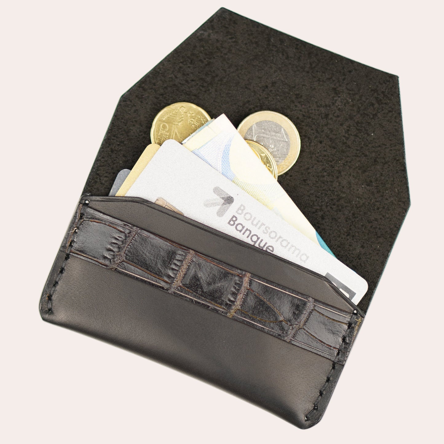 Black wallet with coins and cards on a white background