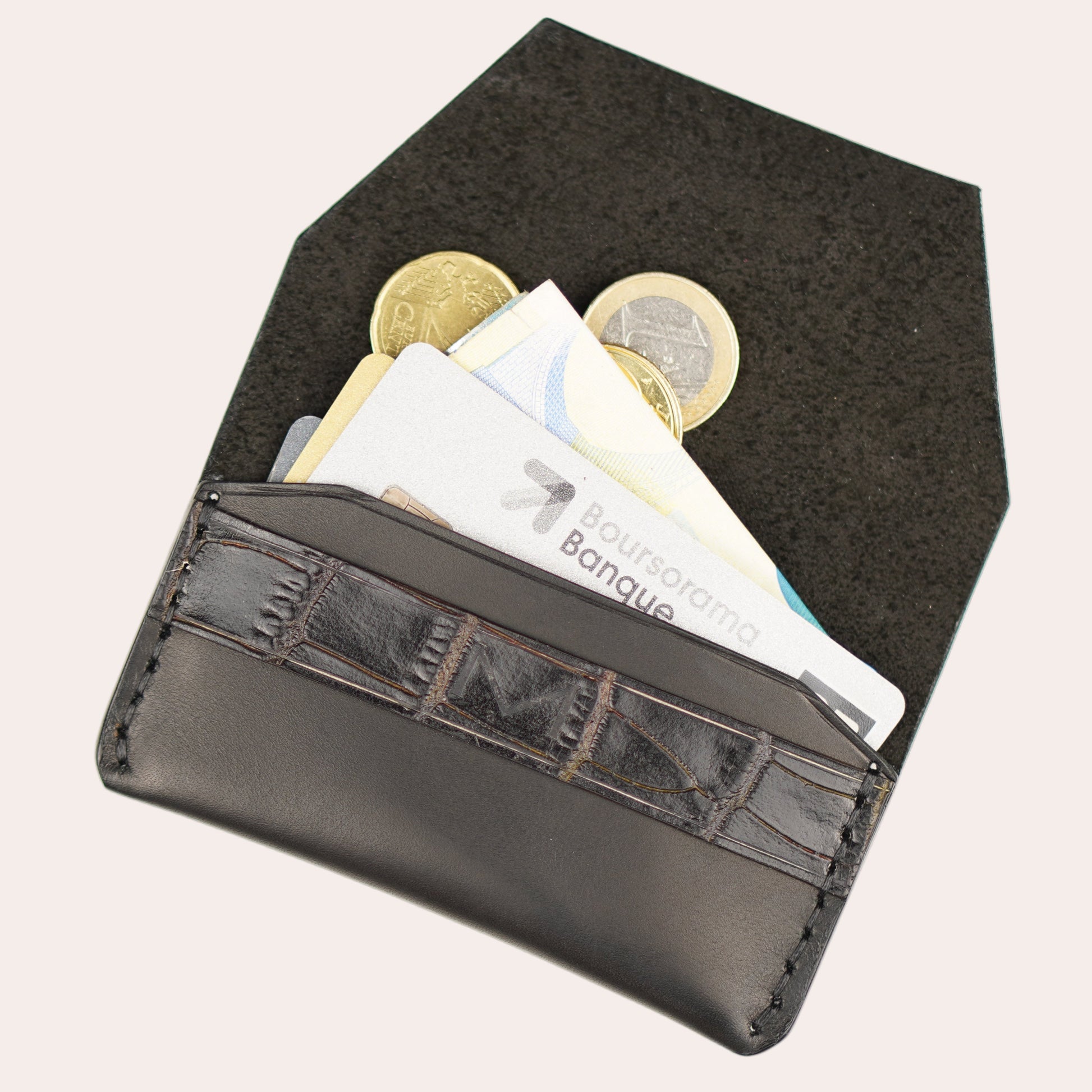 Black wallet with coins and cards on a white background