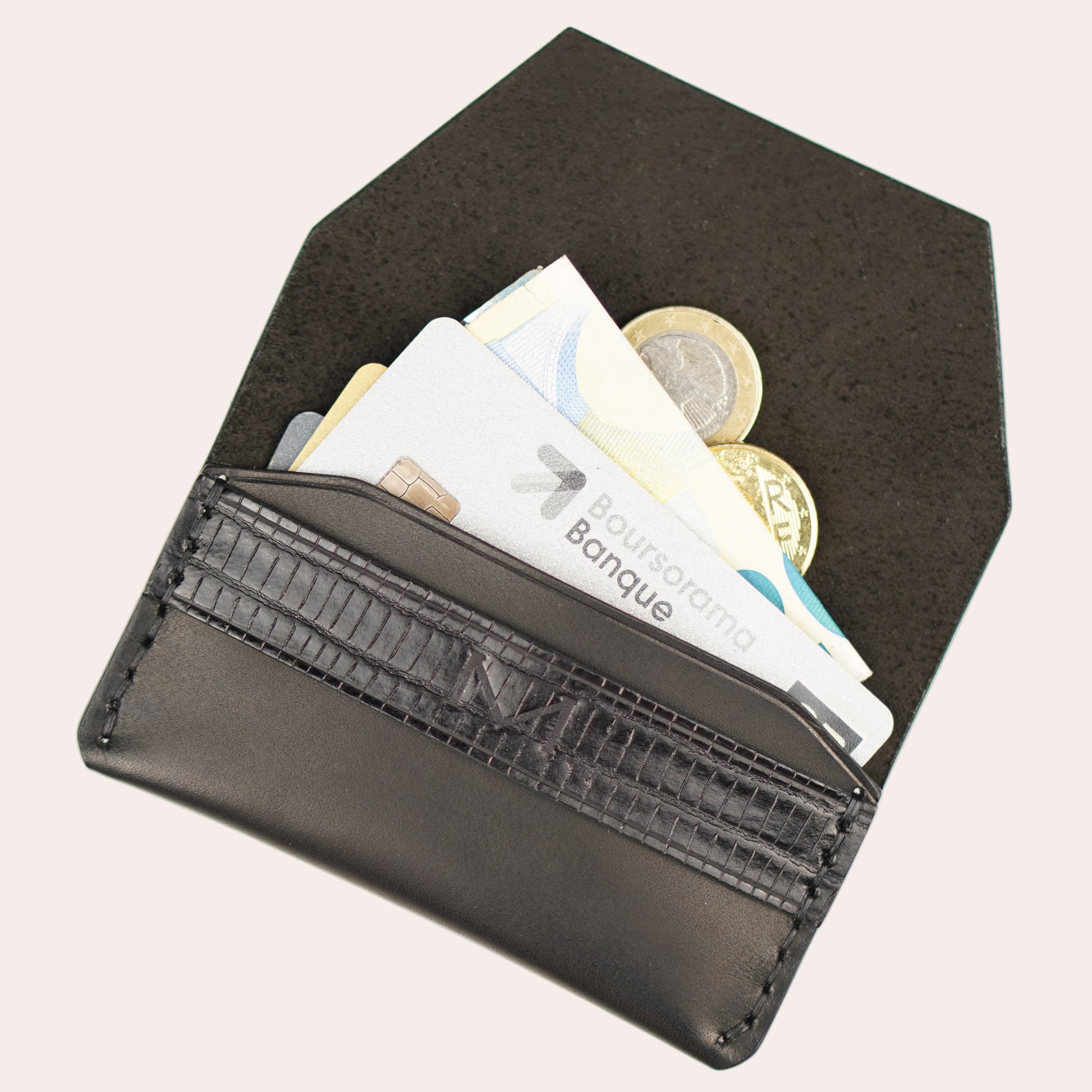 Black wallet with money and coins on a white background