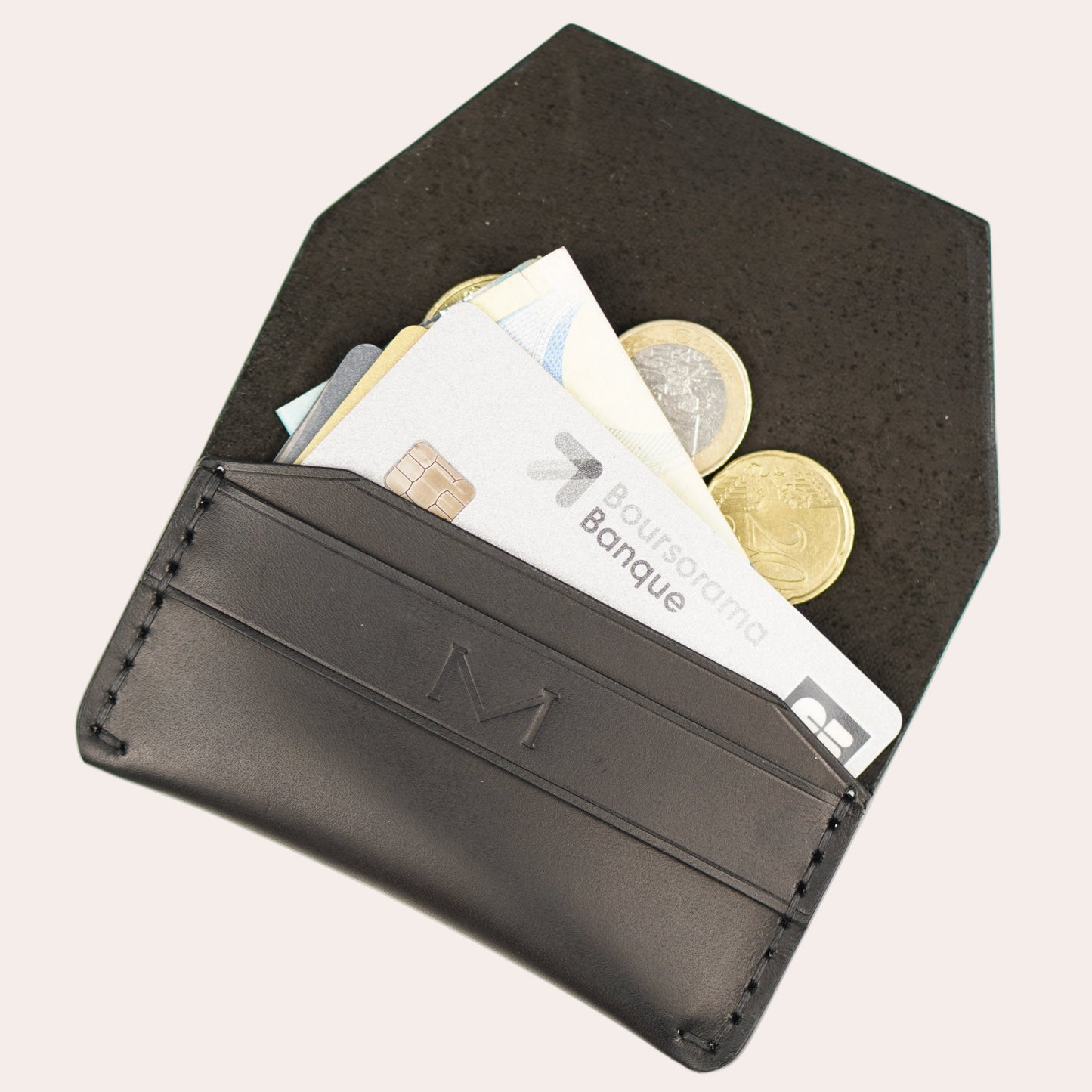Black wallet with coins and cards on a white background