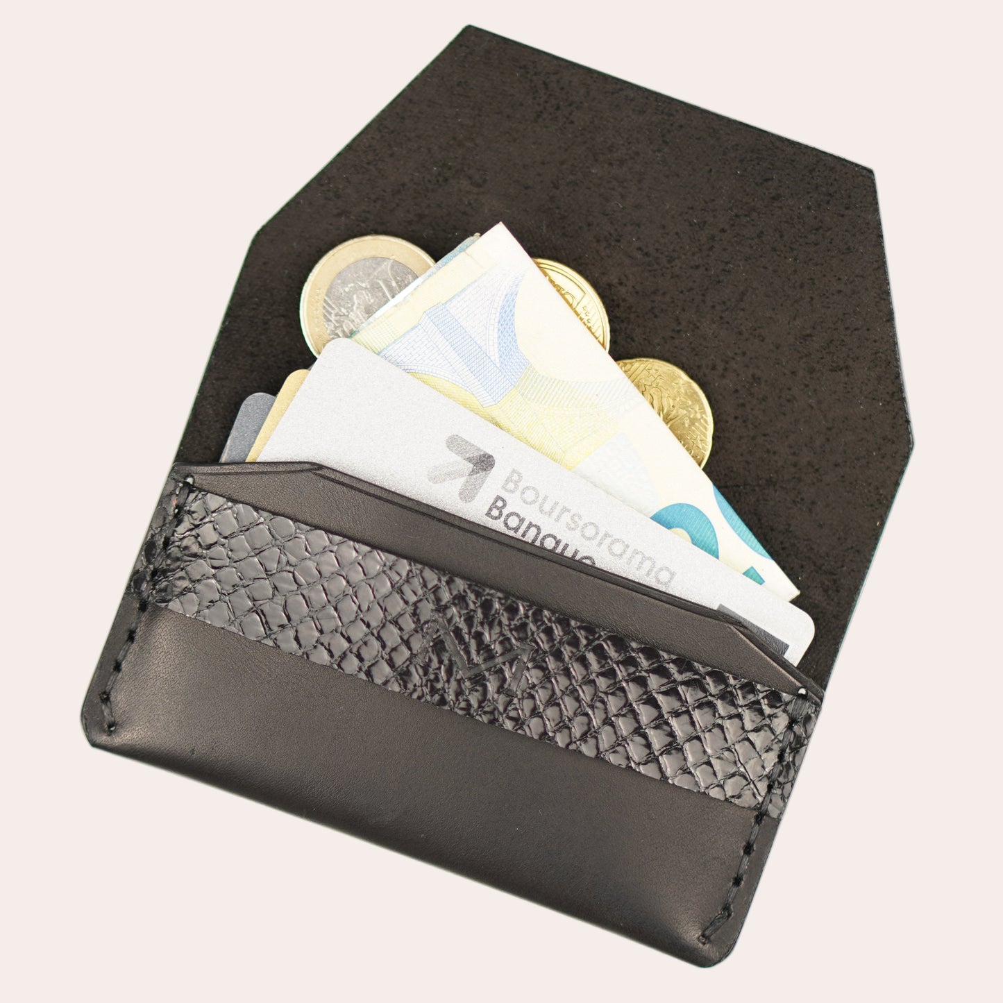 Black wallet with coins and cards on a white background