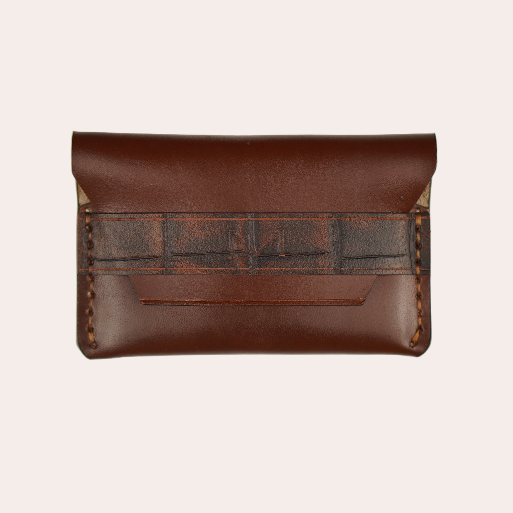 Brown leather clutch with textured pattern on a white background